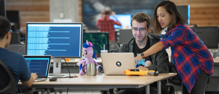 A female mentor coaching a male student on their laptop